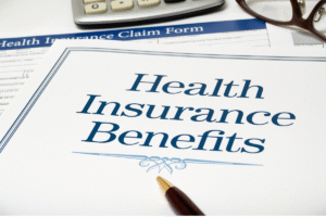 image of a white document with blue letters spelling out "Health Insurance Benefits" and a pen over the document